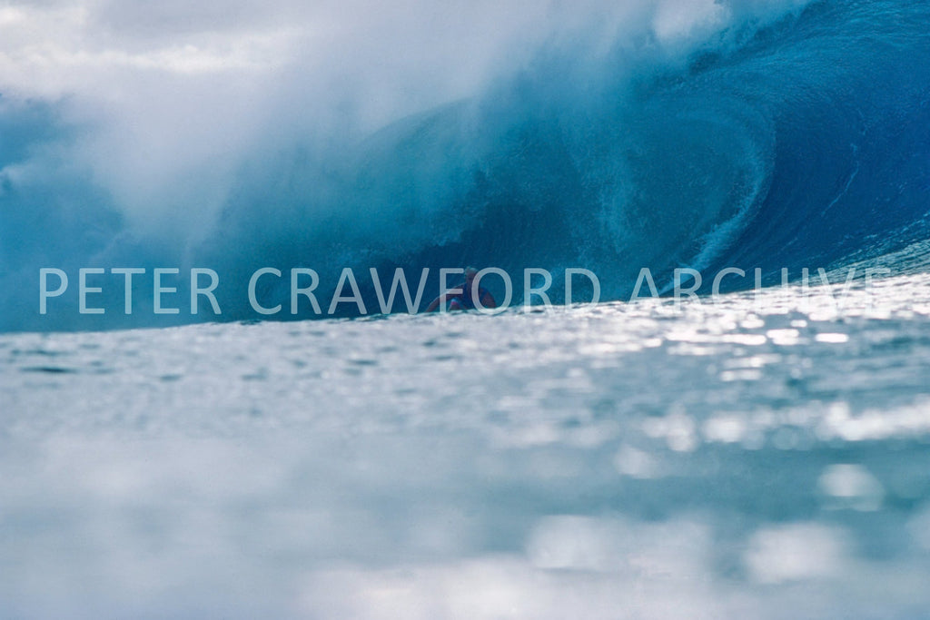 Joey Buran surfing at the 1984 Pipe Masters at Pipeline in Hawaii, photographed by Peter Crawford.
