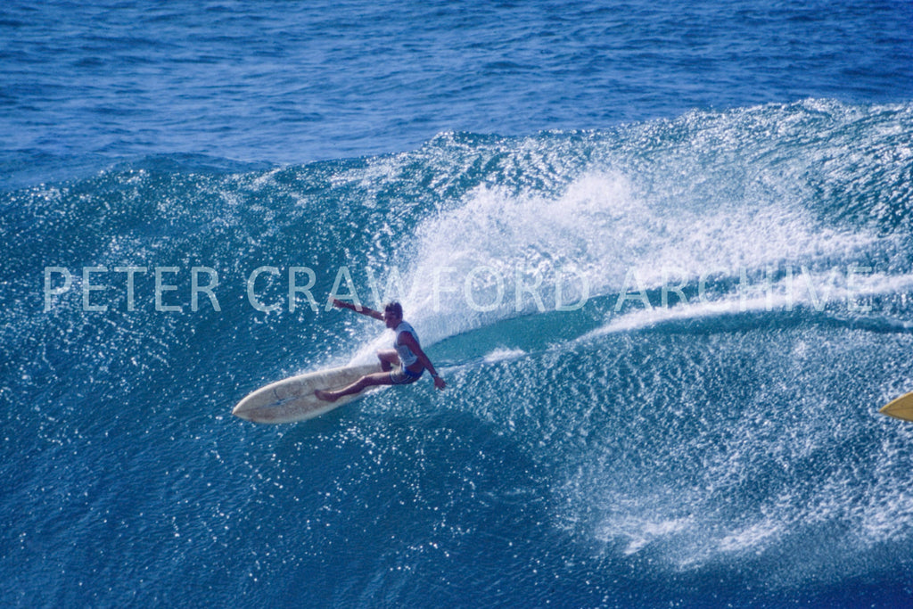 A surfer riding without a leash at Honolua Bay in Hawaii, photographed by Peter Crawford.