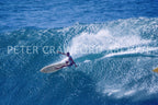 A surfer riding without a leash at Honolua Bay in Hawaii, photographed by Peter Crawford.