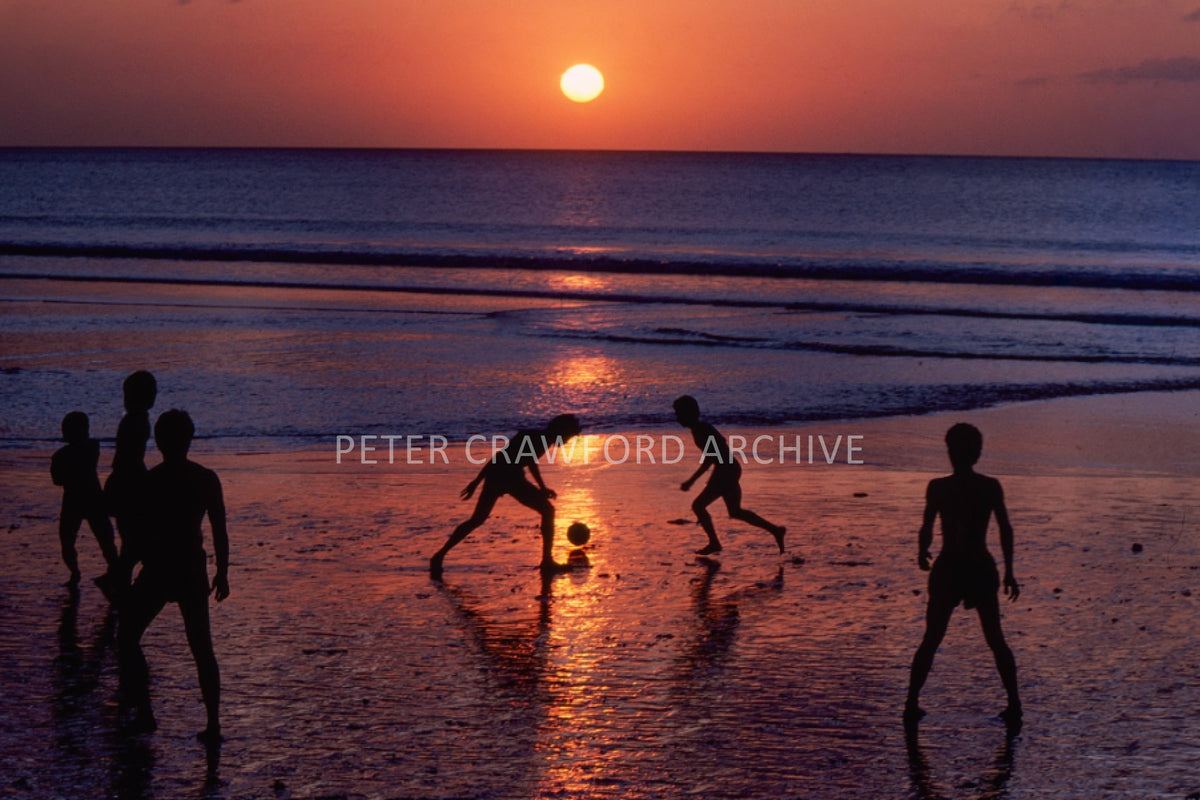 Kids playing soccer at sunset in Kuta, Bali in 1979, photographed by Peter Crawford.