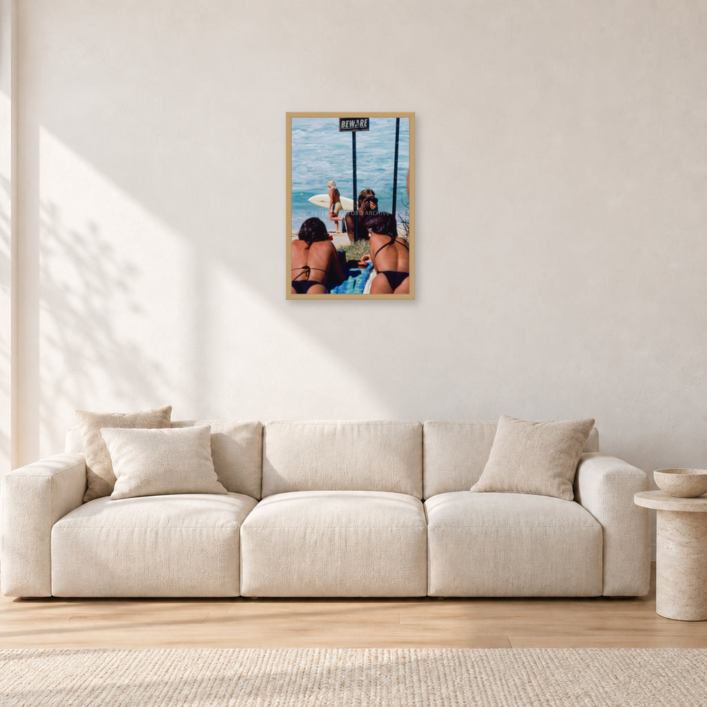 Beware Girls, 1985 by Peter Crawford — 40 × 60 cm, hayseed frame, shown in a light minimalist living room.