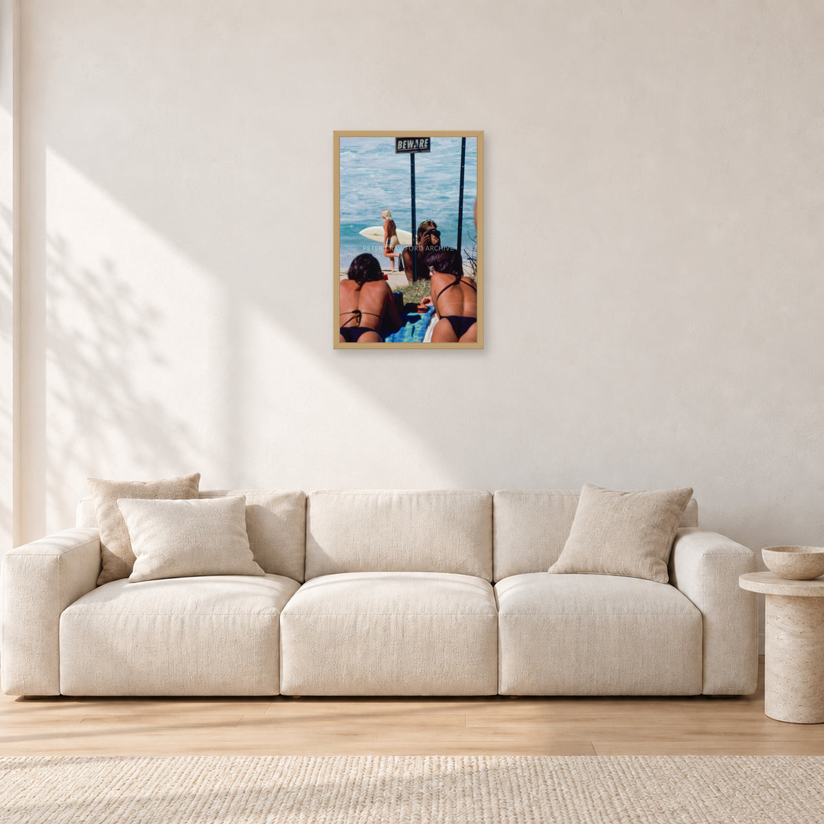 Beware Girls, 1985 by Peter Crawford — 40 × 60 cm, hayseed frame, shown in a light minimalist living room.