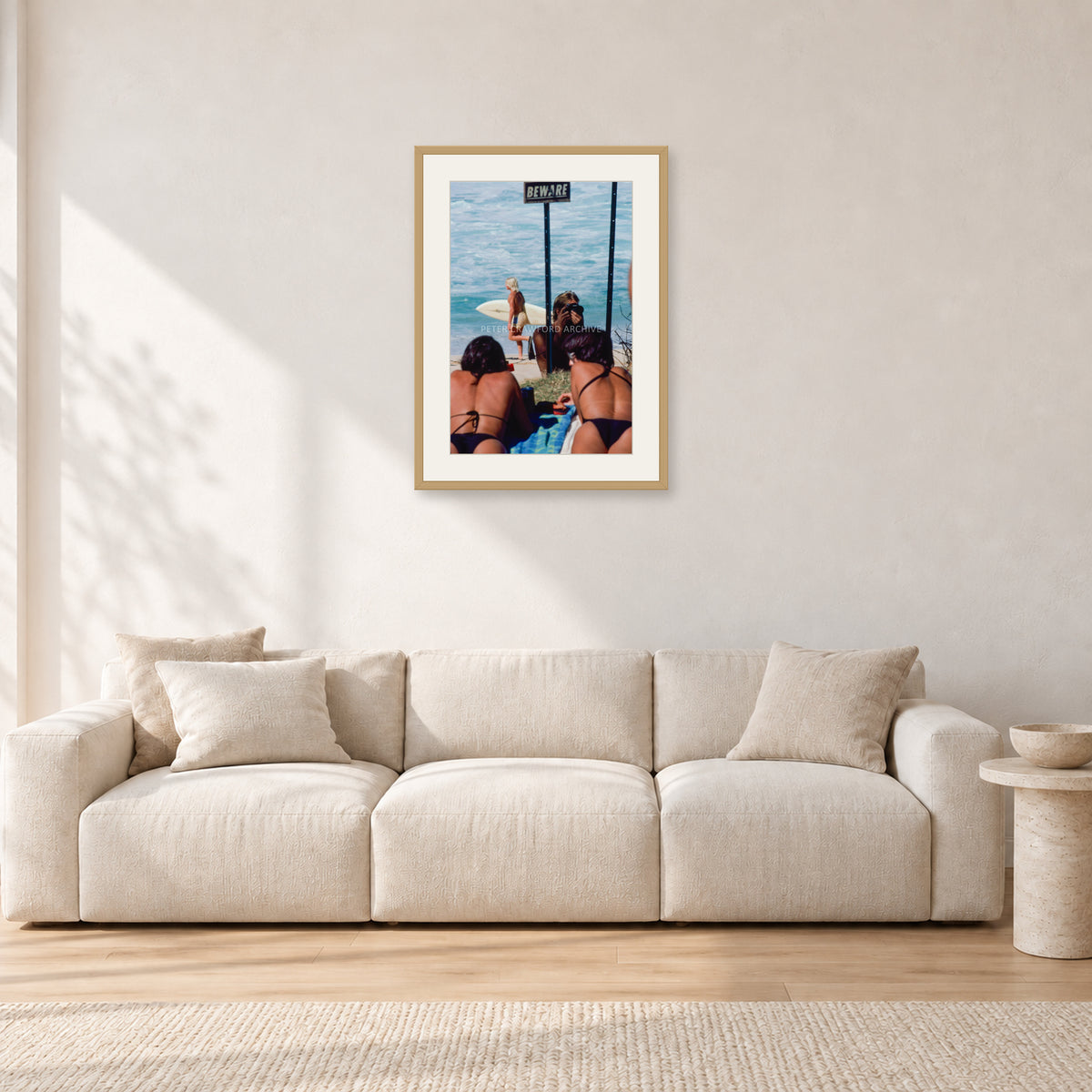 Beware Girls, 1985 by Peter Crawford — 40 × 60 cm, hayseed frame with white mat, shown in a light minimalist living room.