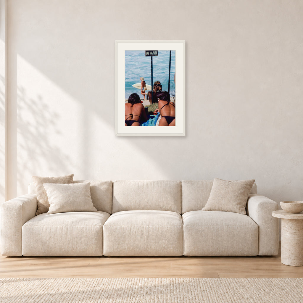 Beware Girls, 1985 by Peter Crawford — 40 × 60 cm, white frame with white mat, shown in a light minimalist living room.