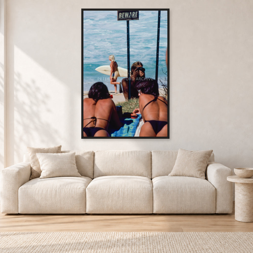Beware Girls, 1985 by Peter Crawford — 80 × 120 cm, black frame, shown in a light minimalist living room.