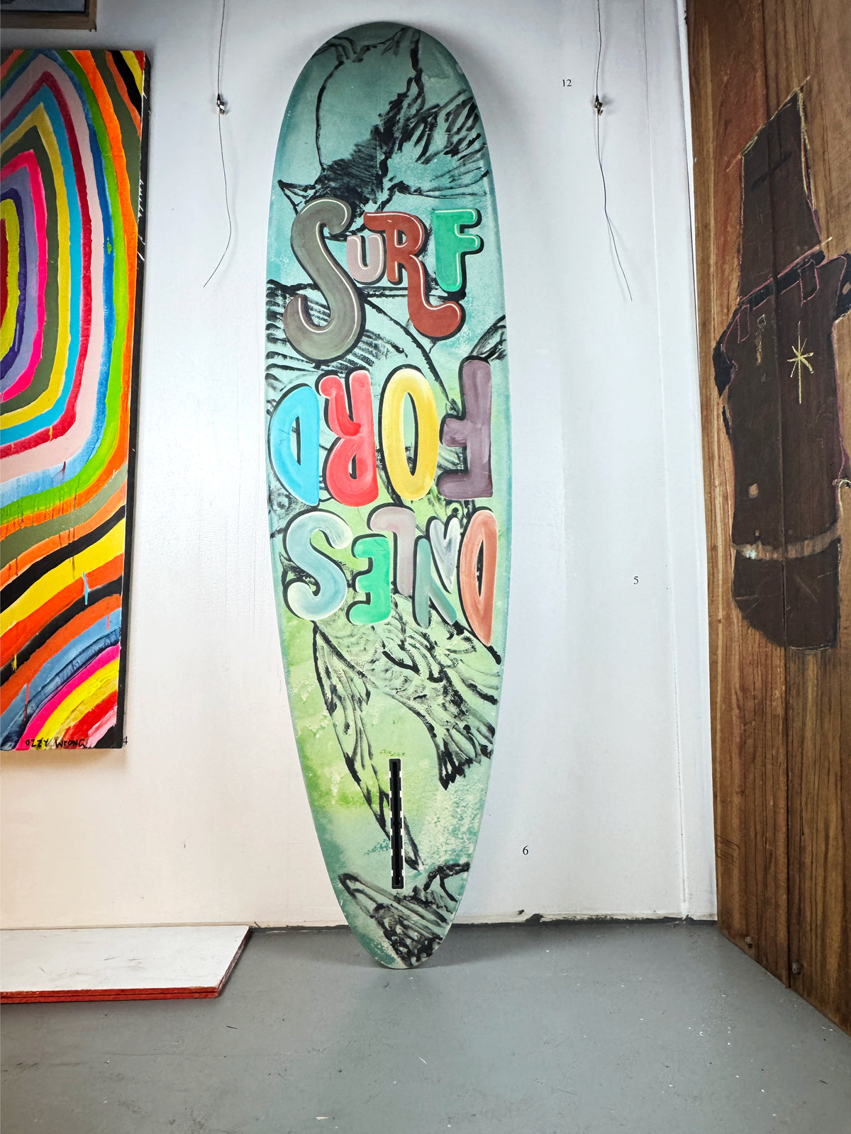 Daylesford Surf Surfboard by David Bromley — lettered side standing in the gallery.