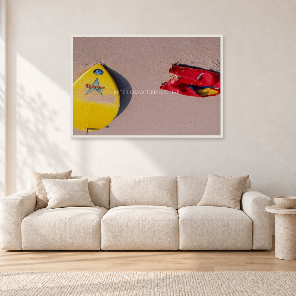 Bells Beach Overview, 1983 by Peter Crawford — 120 × 80 cm, white frame, shown in a light minimalist living room.