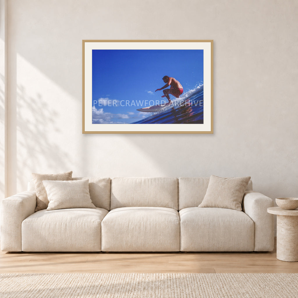 Bruce Raymond, 1976 by Peter Crawford — 90 × 60 cm, hayseed frame with white mat, shown in a light minimalist living room.