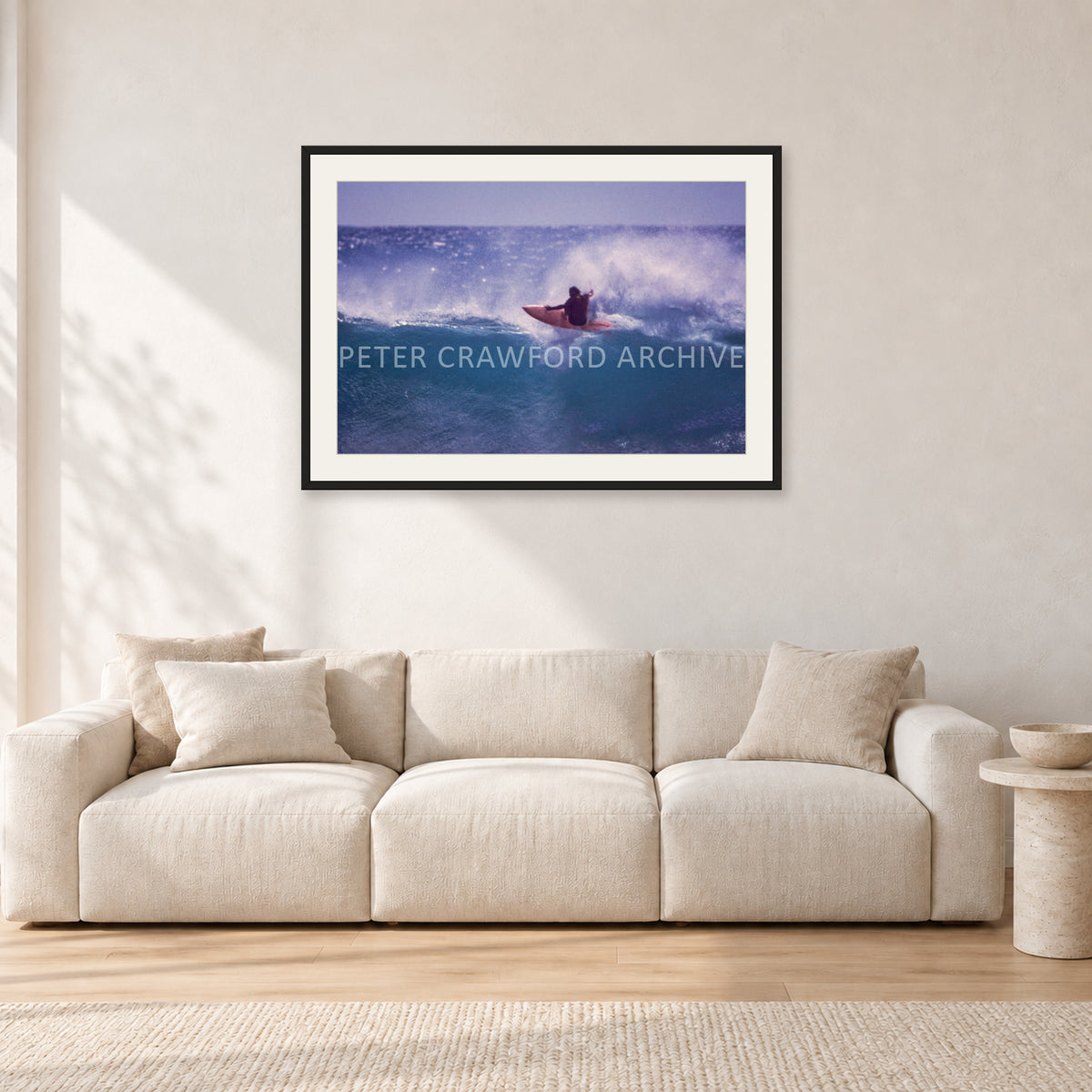 Bruce Raymond, Stubbies 1980 by Peter Crawford — 90 × 60 cm, black frame with white mat, shown in a light minimalist living room.