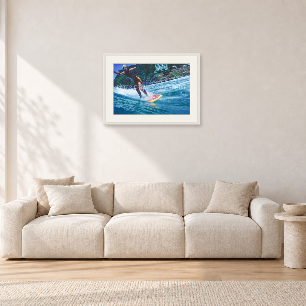 Cheyne Horan, Stubbies 1978 by Peter Crawford — 60 × 40 cm, white frame with white mat, shown in a light minimalist living room.