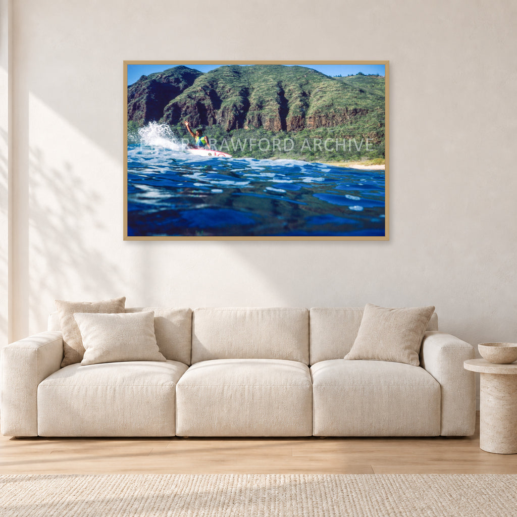 Dane Kealoha, West Side Oahu by Peter Crawford — 120 × 80 cm, hayseed frame, shown in a light minimalist living room.