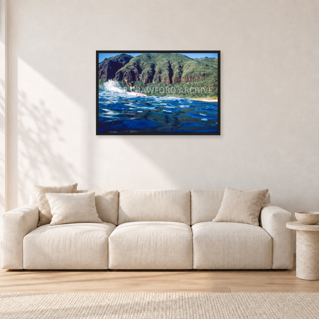 Dane Kealoha, West Side Oahu by Peter Crawford — 90 × 60 cm, black frame, shown in a light minimalist living room.
