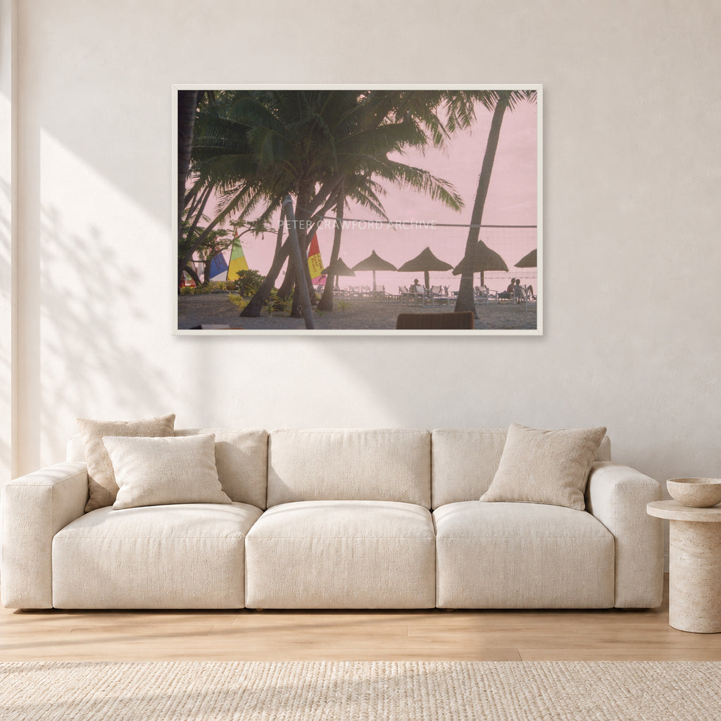 Fiji Sunset I by Peter Crawford — 120 × 80 cm, white frame, shown in a light minimalist living room.