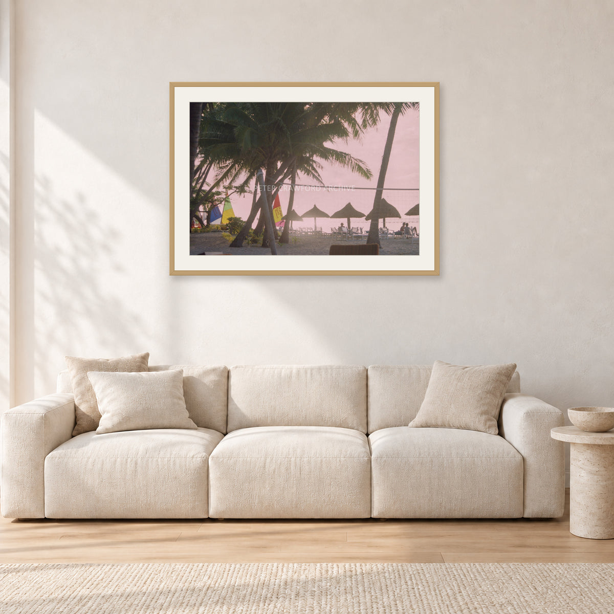 Fiji Sunset I by Peter Crawford — 90 × 60 cm, hayseed frame with white mat, shown in a light minimalist living room.