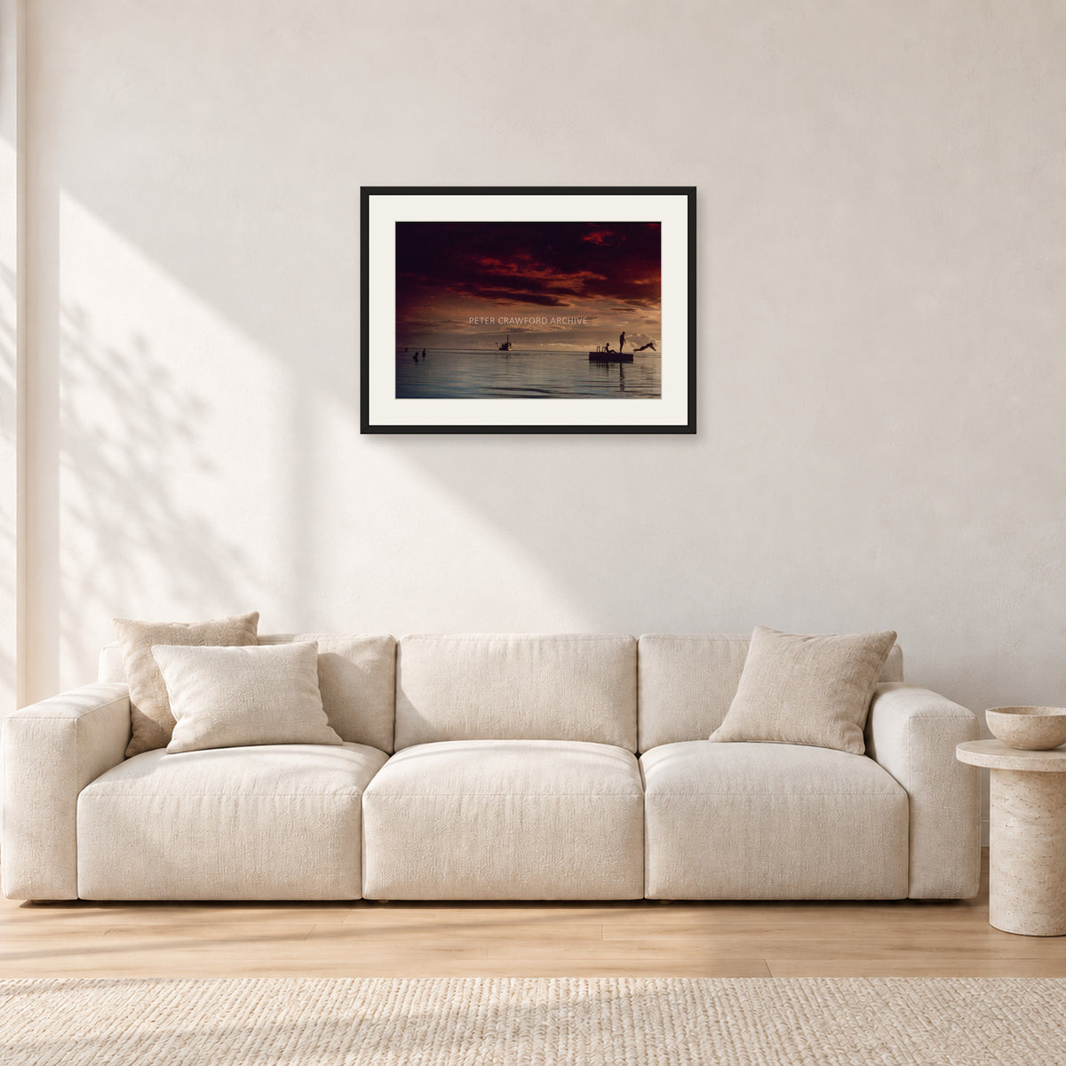 Fiji Sunset II by Peter Crawford — 60 × 40 cm, black frame with white mat, shown in a light minimalist living room.