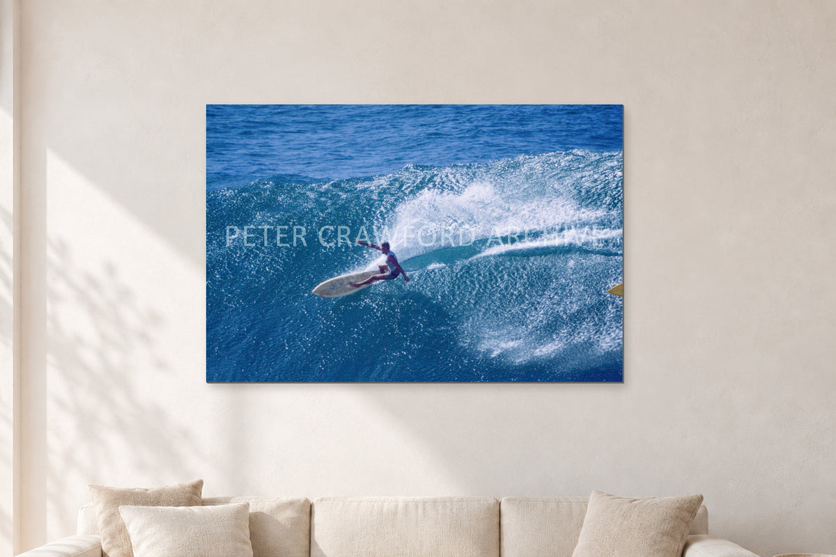 Honolua Bay, No Leash by Peter Crawford — 120 × 80 cm, aluminium-mounted resin print, shown in a light minimalist living room.