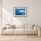 Honolua Bay, No Leash by Peter Crawford — 60 × 40 cm, black frame with white mat, shown in a light minimalist living room.