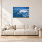 Honolua Bay, No Leash by Peter Crawford — 90 × 60 cm, hayseed frame, shown in a light minimalist living room.