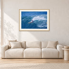 Honolua Bay, No Leash by Peter Crawford — 90 × 60 cm, hayseed frame with white mat, shown in a light minimalist living room.