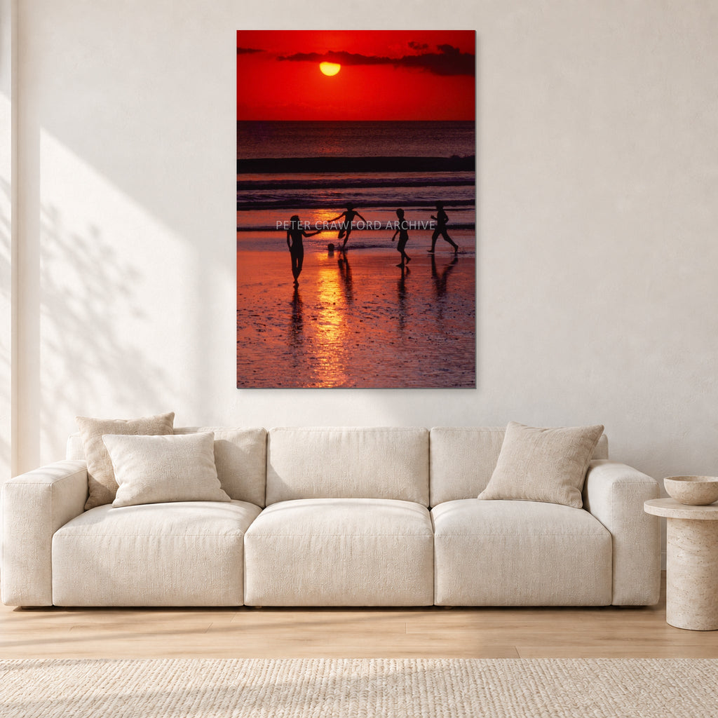 Indonesian Sunset Kids by Peter Crawford — 80 × 120 cm, aluminium-mounted resin print, shown in a light minimalist living room.