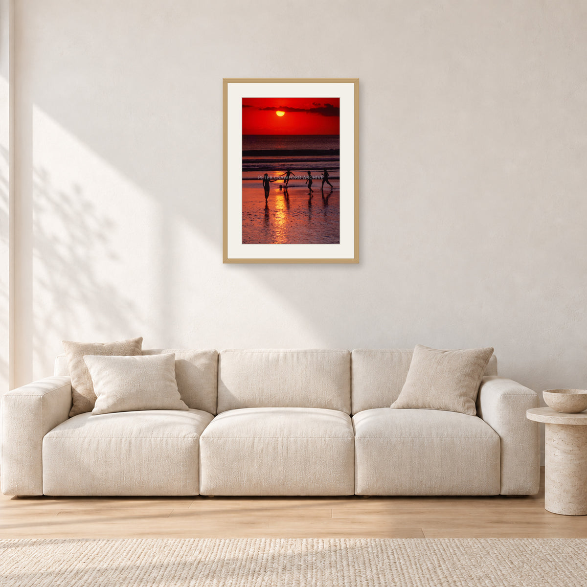 Indonesian Sunset Kids by Peter Crawford — 40 × 60 cm, hayseed frame with white mat, shown in a light minimalist living room.