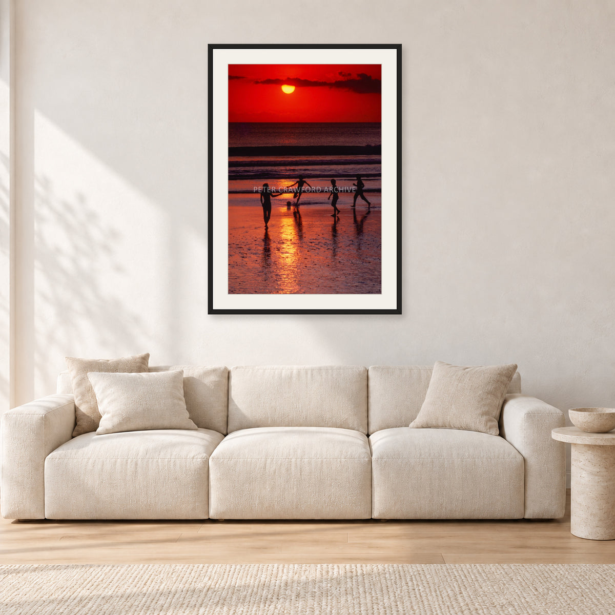 Indonesian Sunset Kids by Peter Crawford — 60 × 90 cm, black frame with white mat, shown in a light minimalist living room.