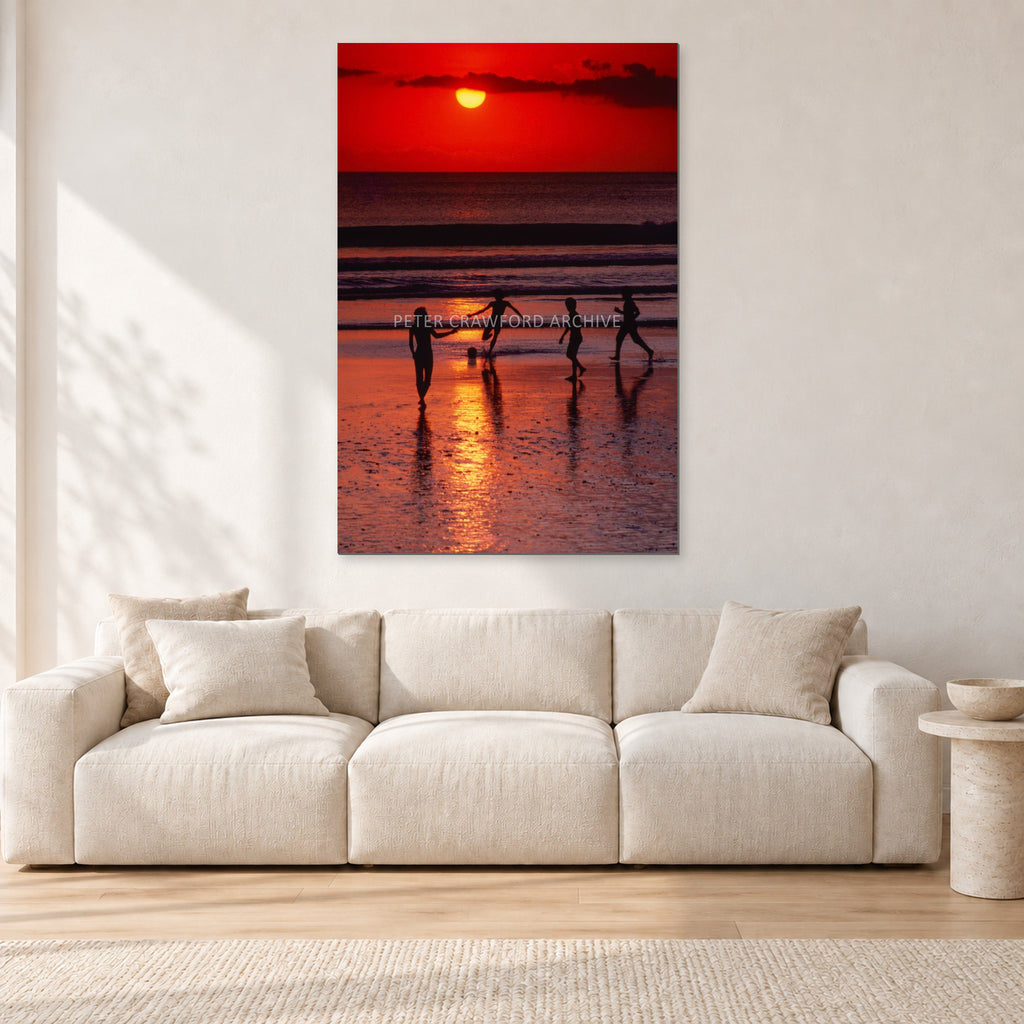 Indonesian Sunset Kids by Peter Crawford — 80 × 120 cm, aluminium-mounted resin print, shown in a light minimalist living room.