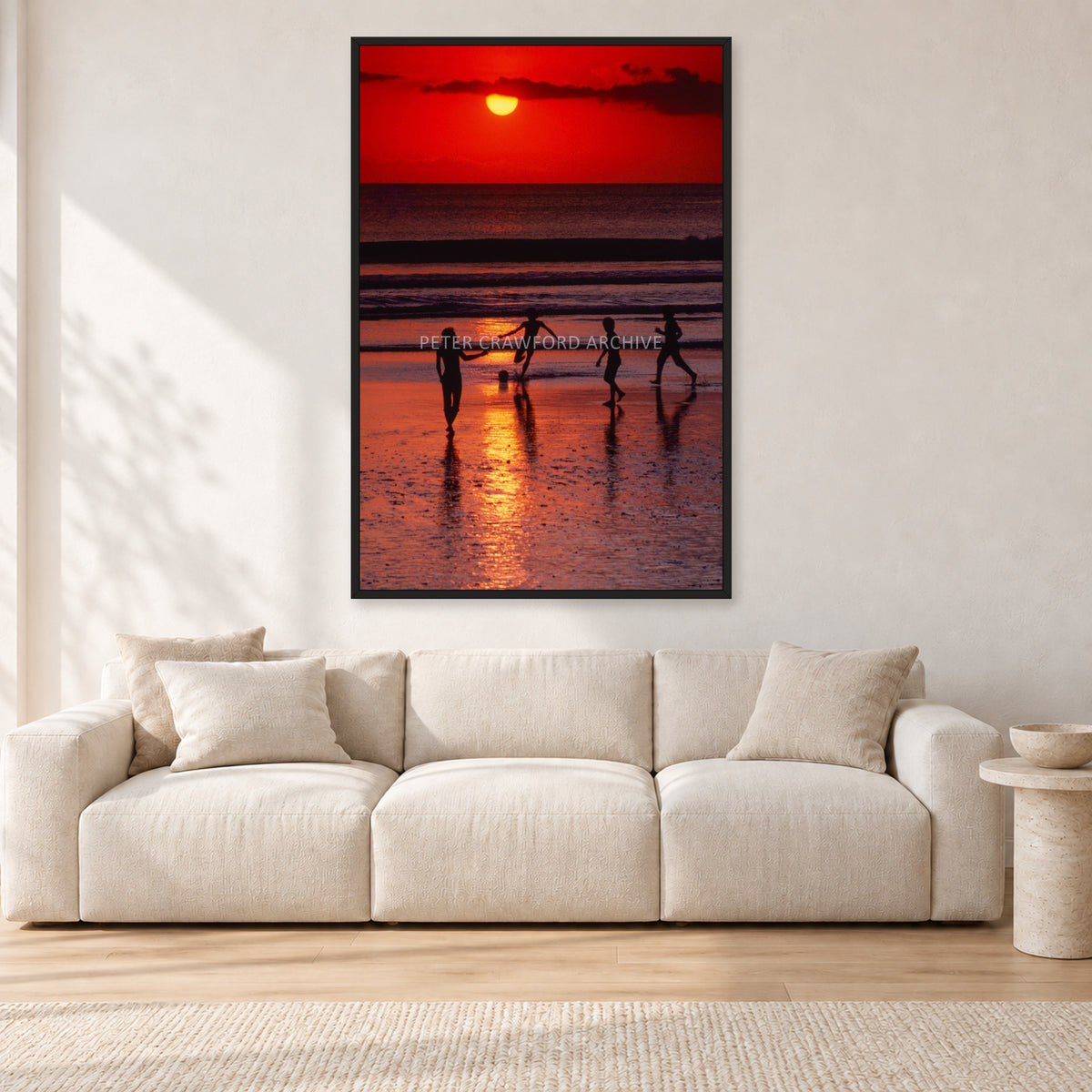 Indonesian Sunset Kids by Peter Crawford — 80 × 120 cm, black frame, shown in a light minimalist living room.