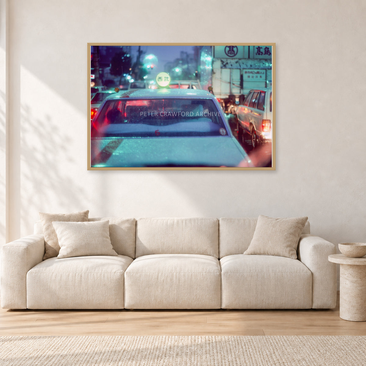 Japan City Lights by Peter Crawford — 120 × 80 cm, hayseed frame, shown in a light minimalist living room.