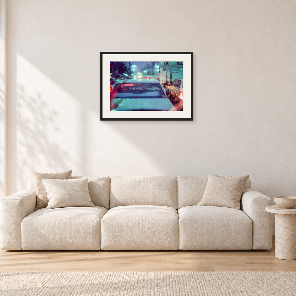 Japan City Lights by Peter Crawford — 60 × 40 cm, black frame with white mat, shown in a light minimalist living room.