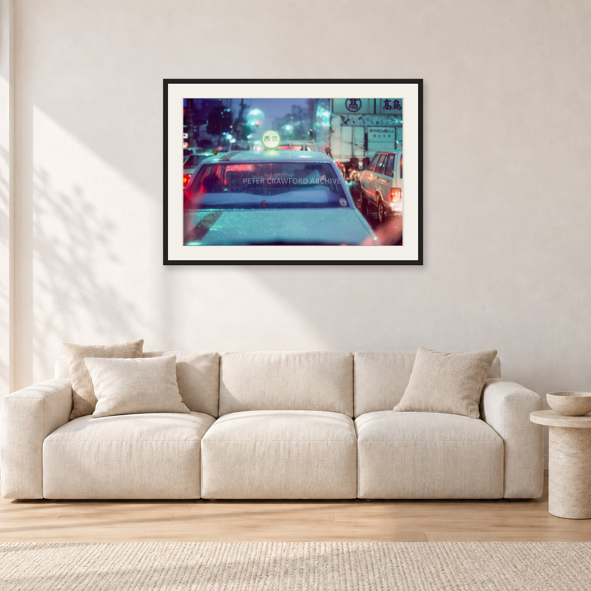 Japan City Lights by Peter Crawford — 90 × 60 cm, black frame with white mat, shown in a light minimalist living room.