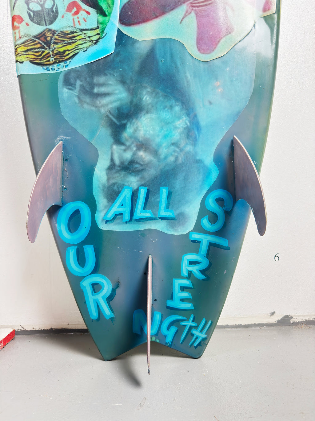 Blue Skulls Surfboard by David Bromley — lower turquoise surface and fins.