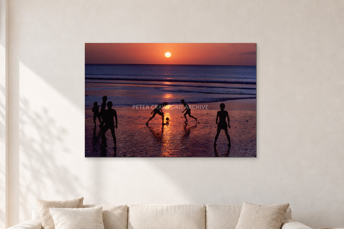 Kuta Kids Soccer, 1979 by Peter Crawford — 120 × 80 cm, aluminium-mounted resin print, shown in a light minimalist living room.