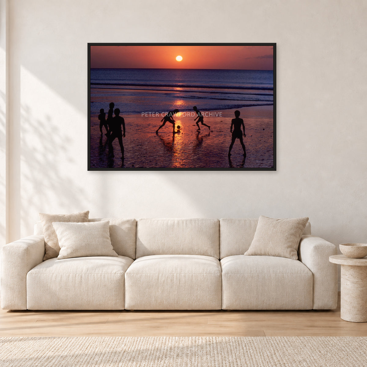 Kuta Kids Soccer, 1979 by Peter Crawford — 120 × 80 cm, black frame, shown in a light minimalist living room.