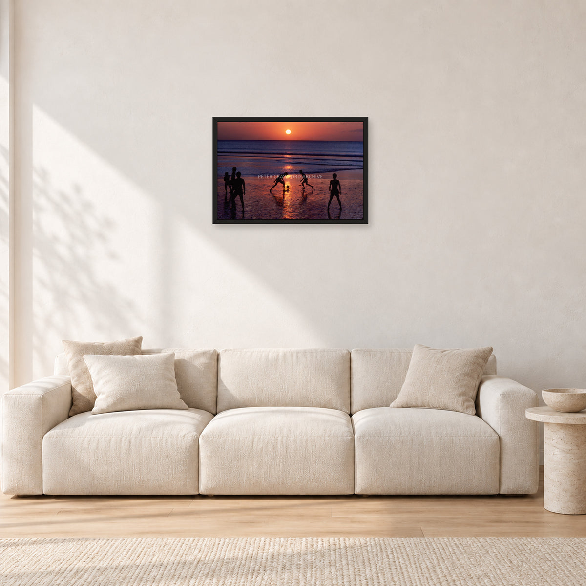 Kuta Kids Soccer, 1979 by Peter Crawford — 60 × 40 cm, black frame, shown in a light minimalist living room.