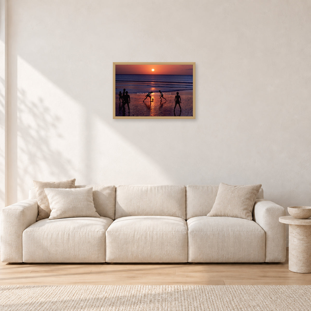 Kuta Kids Soccer, 1979 by Peter Crawford — 60 × 40 cm, hayseed frame, shown in a light minimalist living room.