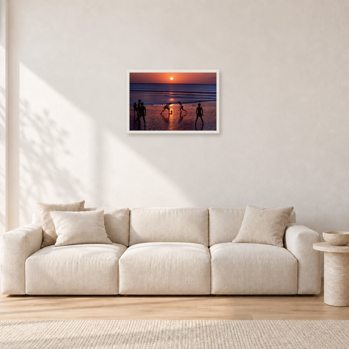 Kuta Kids Soccer, 1979 by Peter Crawford — 60 × 40 cm, white frame, shown in a light minimalist living room.