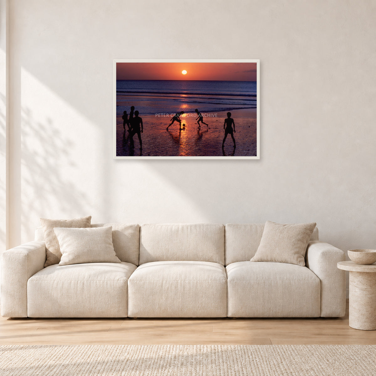 Kuta Kids Soccer, 1979 by Peter Crawford — 90 × 60 cm, white frame, shown in a light minimalist living room.