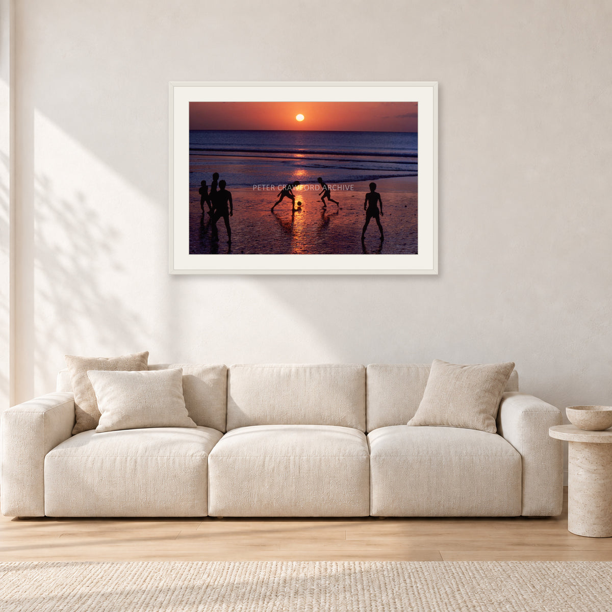 Kuta Kids Soccer, 1979 by Peter Crawford — 90 × 60 cm, white frame with white mat, shown in a light minimalist living room.
