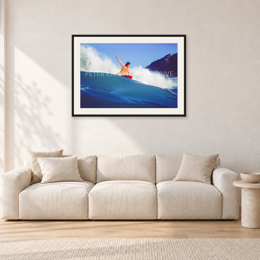 Mark Richards, Bells Beach 1979 by Peter Crawford — 90 × 60 cm, black frame with white mat, shown in a light minimalist living room.