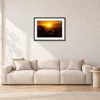 North Shore Sunset by Peter Crawford — 60 × 40 cm, black frame with white mat, shown in a light minimalist living room.