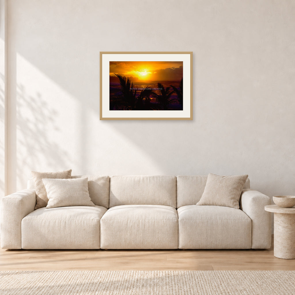 North Shore Sunset by Peter Crawford — 60 × 40 cm, hayseed frame with white mat, shown in a light minimalist living room.