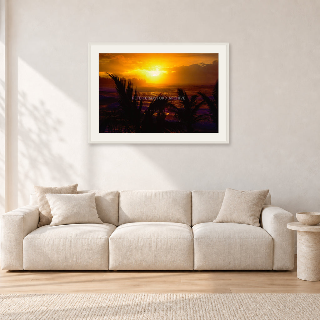 North Shore Sunset by Peter Crawford — 90 × 60 cm, white frame with white mat, shown in a light minimalist living room.