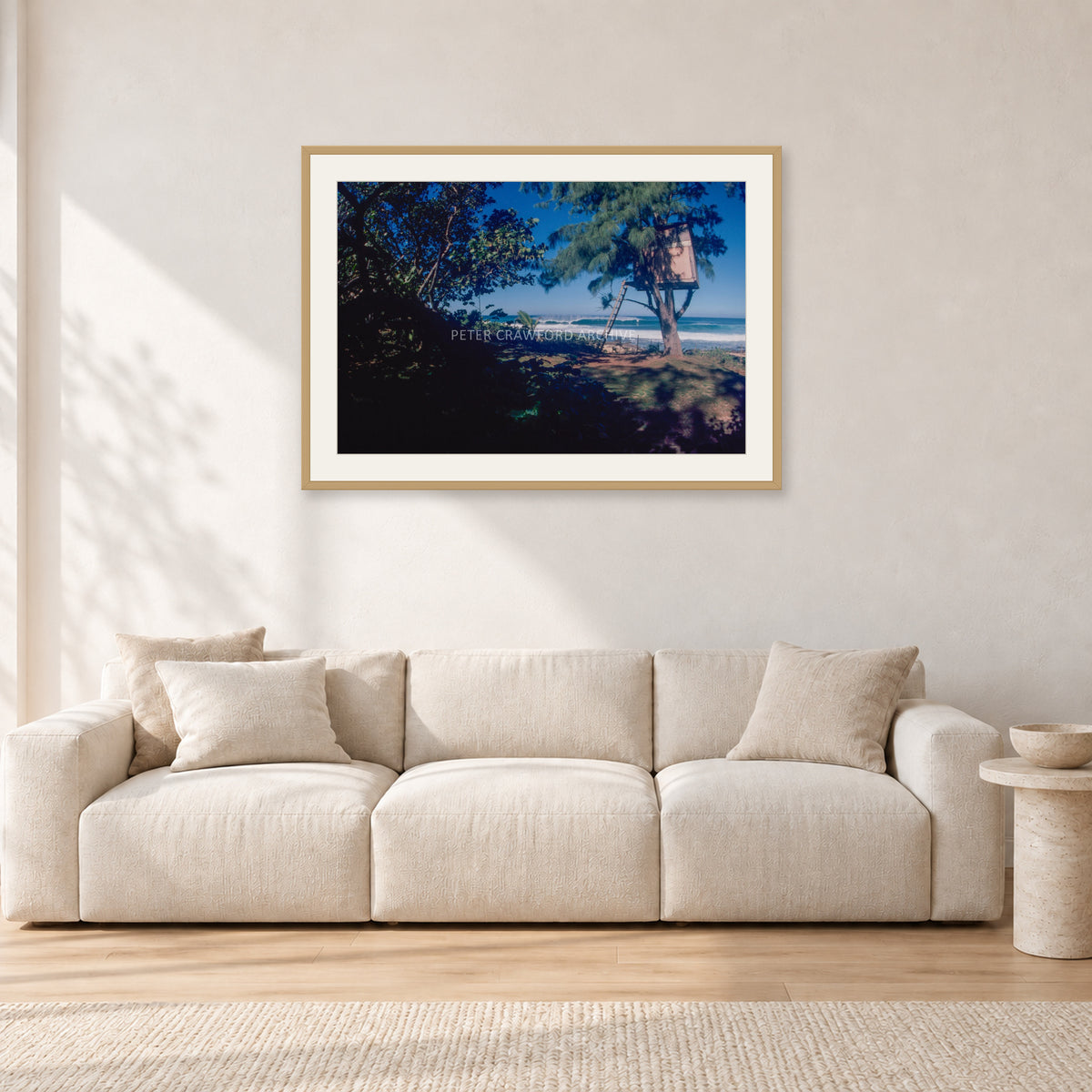 North Shore Tree House, 1978 by Peter Crawford — 90 × 60 cm, hayseed frame with white mat, shown in a light minimalist living room.