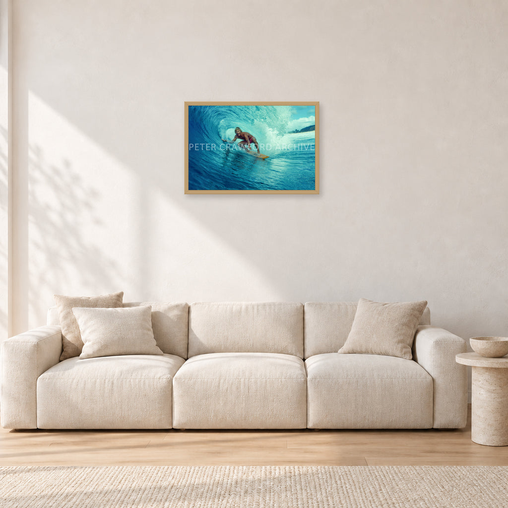 North Shore Tube Ride, Hawaii 1970s by Peter Crawford — 60 × 40 cm, hayseed frame, shown in a light minimalist living room.