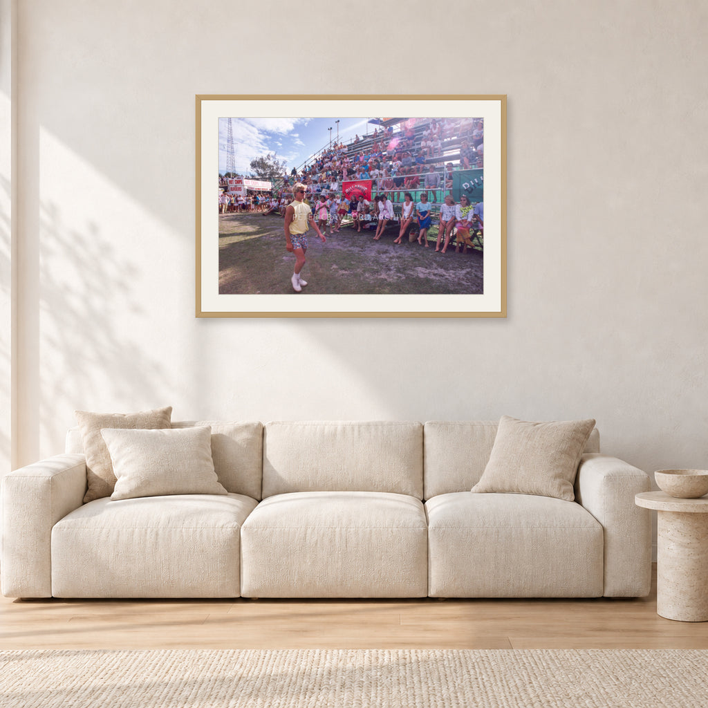 Occy, Duranbah by Peter Crawford — 90 × 60 cm, hayseed frame with white mat, shown in a light minimalist living room.