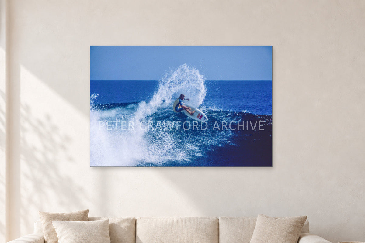 Occy, Top Turn 1984 by Peter Crawford — 120 × 80 cm, aluminium-mounted resin print, shown in a light minimalist living room.