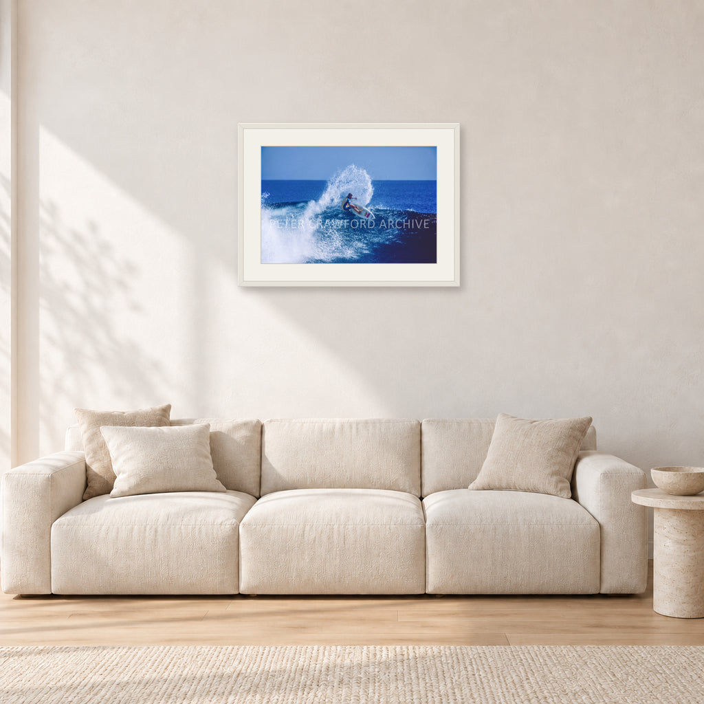 Occy, Top Turn 1984 by Peter Crawford — 60 × 40 cm, white frame with white mat, shown in a light minimalist living room.