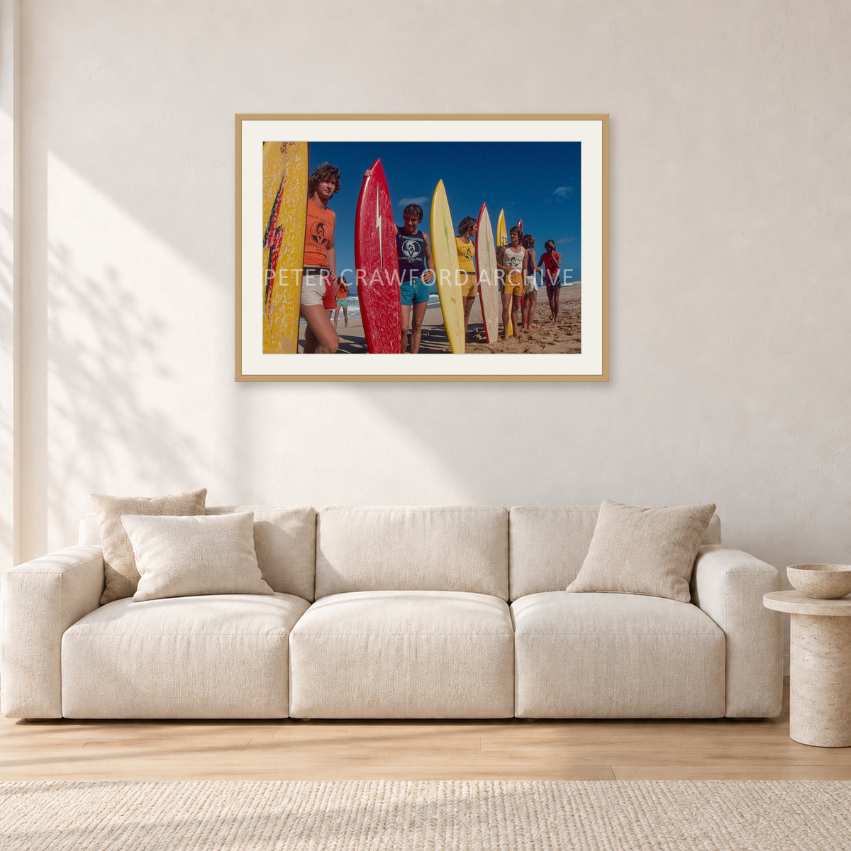 Pipe 76 Rory Russell Mike Armstrong Paul Naude by Peter Crawford — 90 × 60 cm, hayseed frame with white mat, shown in a light minimalist living room.
