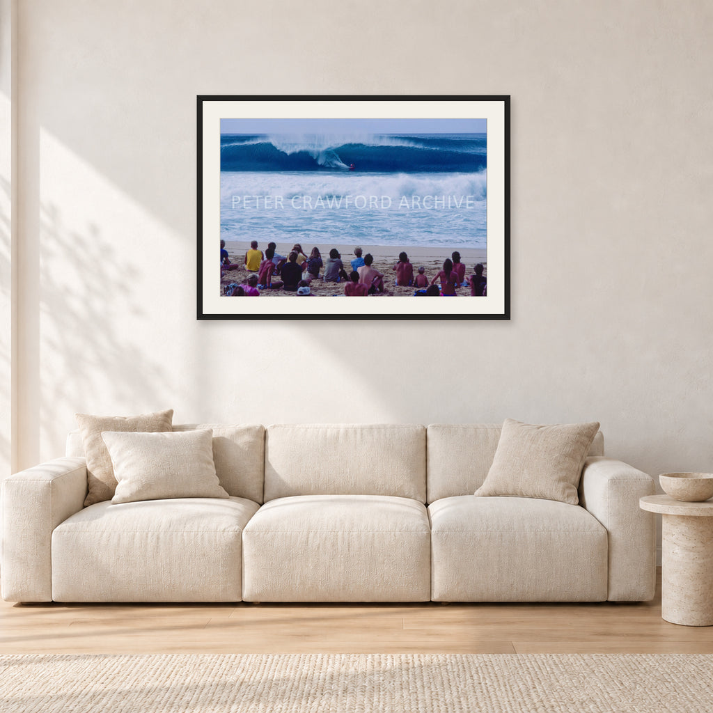 Pipe Masters, Pipeline 1988 by Peter Crawford — 90 × 60 cm, black frame with white mat, shown in a light minimalist living room.